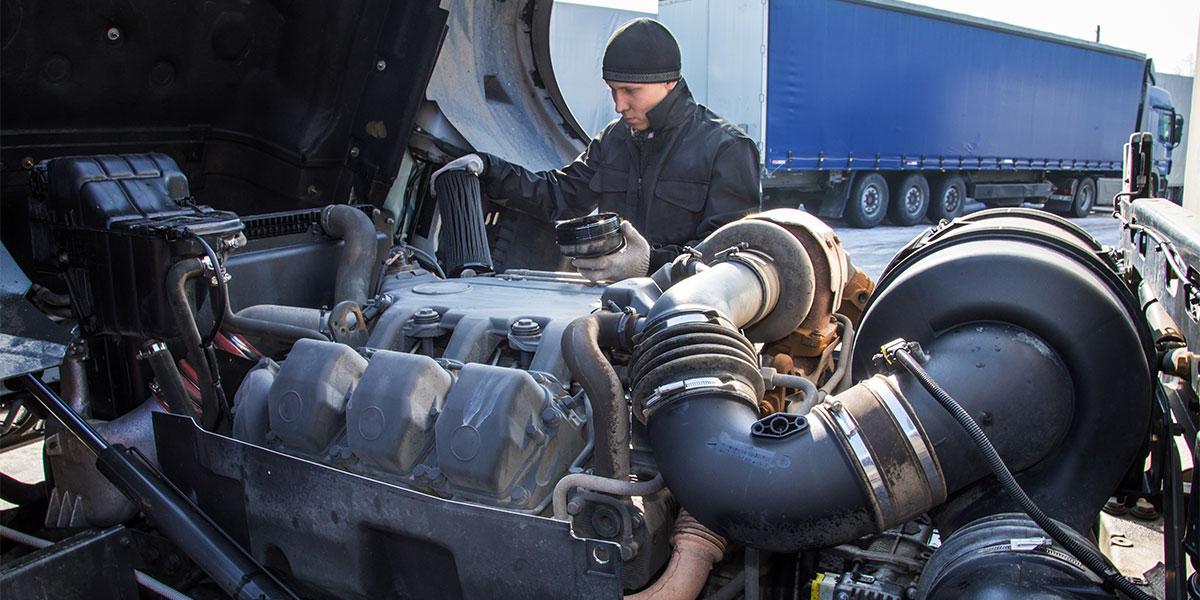 Student surveying large diesel engine.