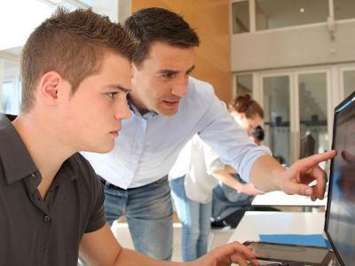 Instructor 和 student using a computer.